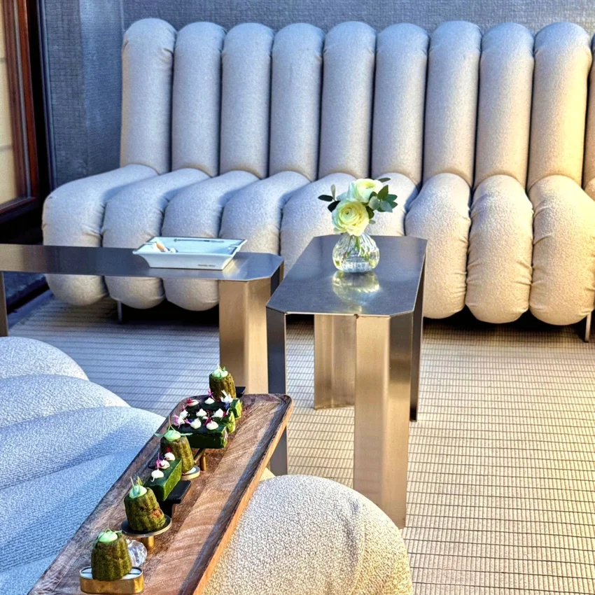 Elegant seating area with a food presentation and floral arrangements during a Quintet Group event in Milan.