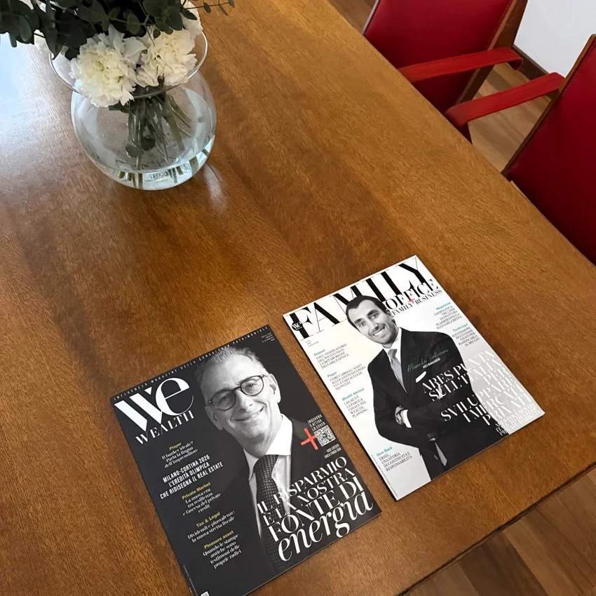 Branded magazines displayed on a wooden table during a Quintet Group event in Milan.